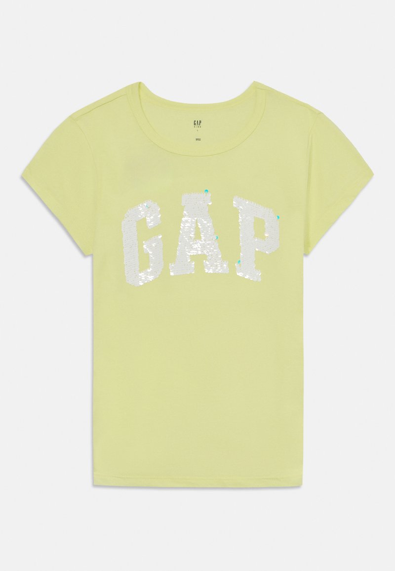 Lys gul kortermet t-skjorte med et hvitt paljettbelagt "GAP"-logo foran. Myk stoff med rund hals og rett kant.