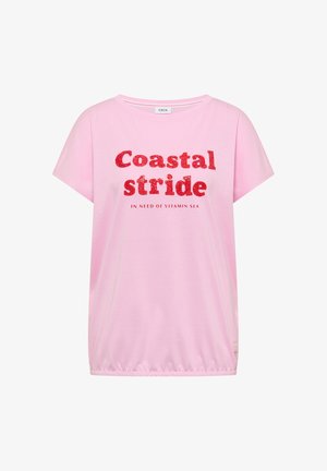 Jasnoróżowa koszula z krótkim rękawem z czerwonym brokatowym napisem "Coastal stride" i mniejszym napisem "In need of vitamin sea" z przodu, elastyczny mankiet na dole.