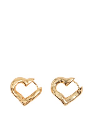 Par de aros en forma de corazón dorados y brillantes con un diseño ligeramente irregular y grueso, sobre fondo blanco.