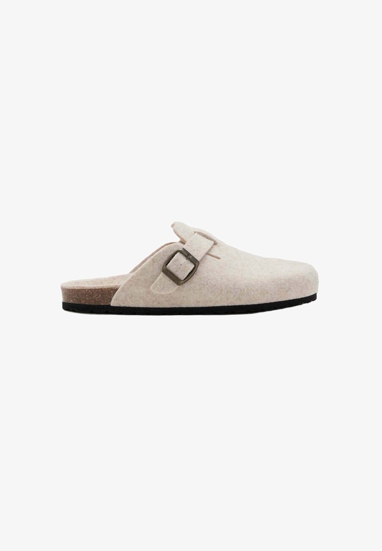 Sabot beige à enfiler avec une bride réglable à boucle, semelle intérieure en liège et semelle noire, montré de côté sur fond blanc.
