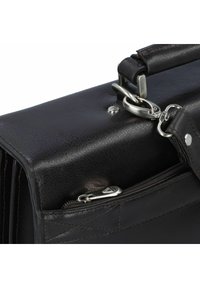 Zwarte leren tas met gegroefde afwerking, zilveren metalen accenten, handvat bovenop en ritszakdetail. Rechthoekige vorm met zichtbare stiksels.