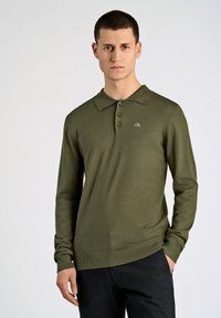 Langärmliges olivgrünes Poloshirt mit klassischem Kragen, drei Kn�öpfen und geripptem Saum. Mit dezentem Logodetail auf der Brust.