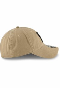 Gorra de béisbol beige hecha de algodón, con visera cosida, seis ojales de ventilación y un acento negro en el lateral.