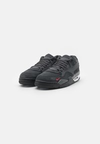 Nike-sneakers med en mørkegrå semsket overdel, snøring og gummisåle. Har en liten rød logo på siden og synlig luftputing.