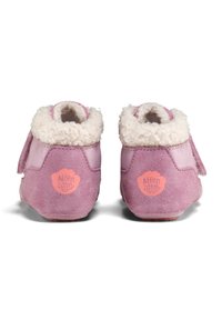 Rosa Wildlederschuhe für Babys mit weißem Fleecekragen und Klettverschluss. Mit einem runden Logo in Rosa an der Ferse. Weiche Textur.