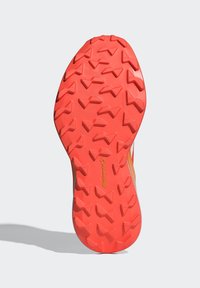 Suola di scarpa in gomma arancione con un design texturizzato e lugs triangolari per una maggiore aderenza, con il logo "Continental" stampato sul lato inferiore.