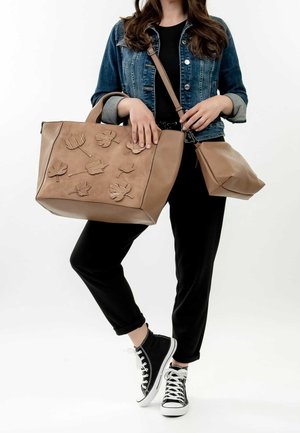 Bolso tote de cuero marrón con patrones de hojas, cuenta con dos asas y una correa para el hombro ajustable. Incluye un pequeño estuche complementario.