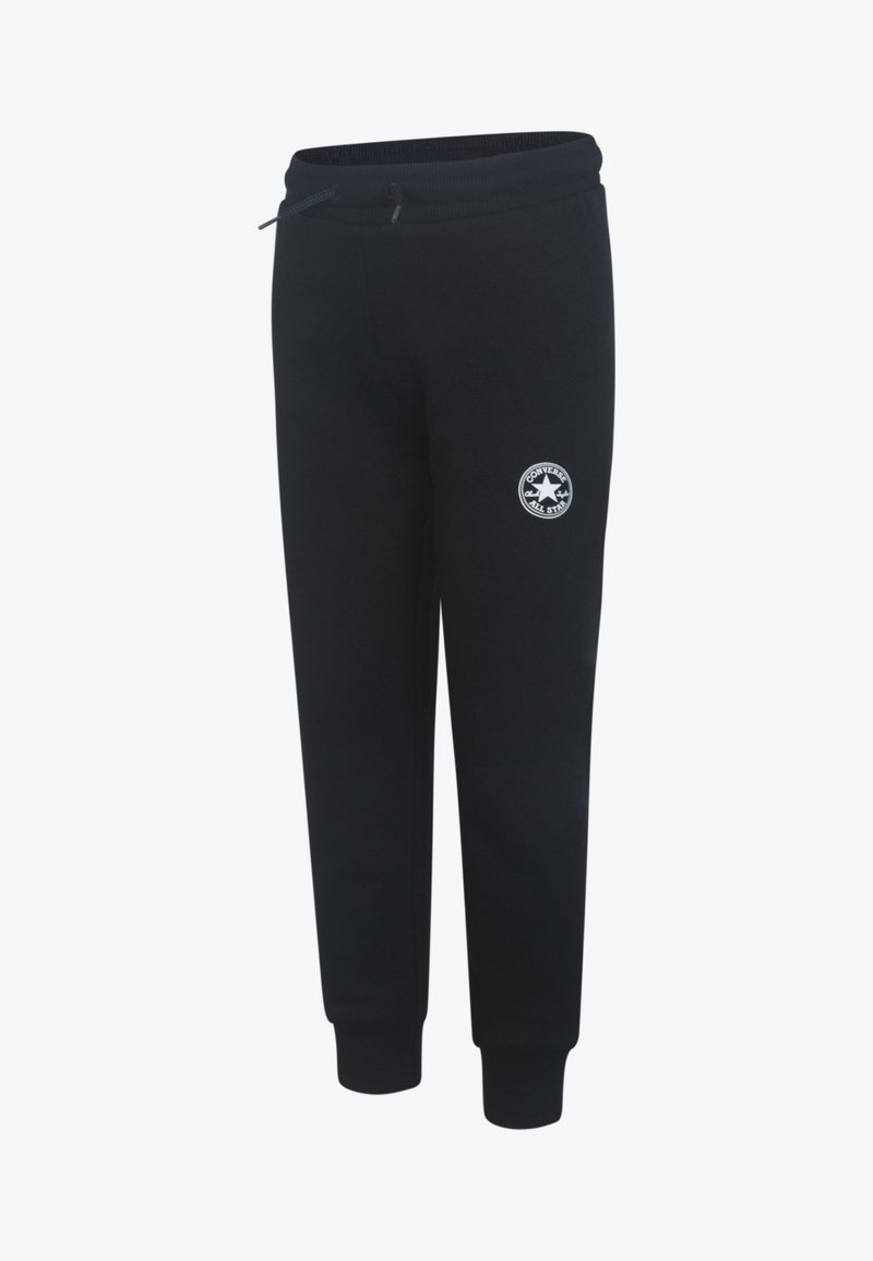 Pantalones de chándal negros con cinturilla elástica, cordón y puños acanalados. Presenta un parche redondo de logotipo blanco en el muslo izquierdo.