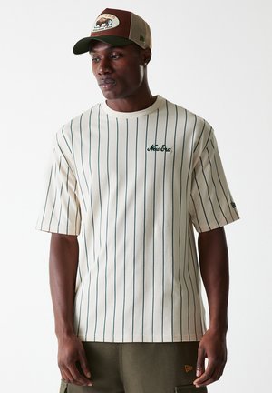 Cream striped t-shirt with green vertical lines, featuring a round neck and embroidered "New Era" logo. Worn with olive cargo pants.