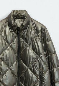 Veste matelassée gris métallique avec col montant, fermeture éclair frontale et poche zippée sur le côté droit.