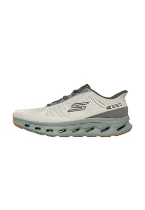 Hellgrauer Skechers Slip-On Sportschuh mit grauen Schnürsenkeln, atmungsaktivem Mesh-Obermaterial, gepolsterter Sohle mit Belüftungslöchern und dezenten orangefarbenen Akzenten.