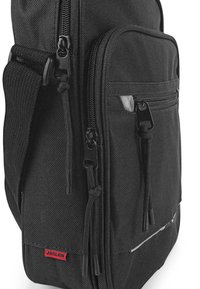 La mochila negra cuenta con un tejido duradero, múltiples compartimentos con cremallera, correas ajustables y una etiqueta de logo rojo prominente.