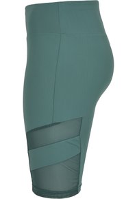 Leggings yoga turchesi con un'alta vita, dotati di un pannello in rete sulla parte inferiore della gamba e accenti in tessuto diagonali. Materiale liscio e elasticizzato.