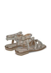 Sandalen in lichtgrijs leer met decoratieve rhinestones, open neus ontwerp, gespband, en textuuraccenten met plooien. Platte zool.