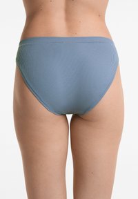 Ljusblå ribbade bikiniunderdelar med medelhög midja och sömmar, som framhäver en slät yta och strömlinjeformat design.