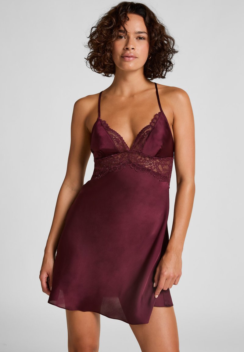 Burgunderfarbenes Satin-Nachthemd mit Spitzenakzenten, tiefem V-Ausschnitt, dünnen Trägern und einer fließenden, leichten Textur. Elegante und figurbetonte Silhouette.