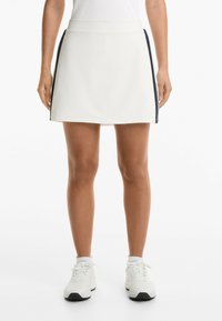 White athletic skirt with dark side stripes, made of lightweight material. Features a smooth texture and a comfortable waistband.