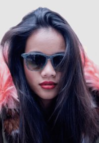 El cabello largo y oscuro enmarca un rostro que lleva unas gafas de sol de color verde transparente con forma redonda. Un collar de piel de color rosa añade textura y contraste.