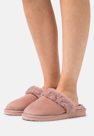 Pink suede slippers with fluffy fur trim and textured soles, featuring a slip-on design and rounded toe.