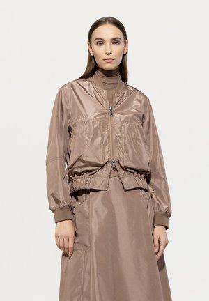 Braune, leichte Bomberjacke mit Reißverschluss, elastischem Bund und Bündchen. Glatte Textur und minimalistisches Design.