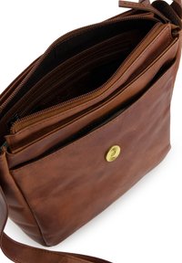 Hnědá kožená crossbody taška s hladkým povrchem, zipovými přihrádkami a mosazným zacvakáváním. Obsahuje nastavitelné rameno.