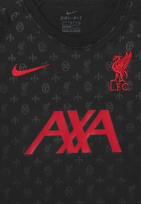 Mustapaitainen urheilupaita, jossa on punainen Nike-logo, Liverpool FC -embleemi ja AXA-sponsoriteksti. Taustalla on hienovaraisesti toistuviin seuran symboleihin perustuva kuvio.