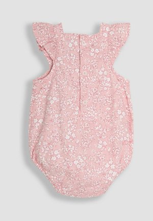 Salopetă florală dintr-un material roz deschis, cu modele de flori albe, mânici volănaș, închidere cu buton la spate și un fund rotunjit.