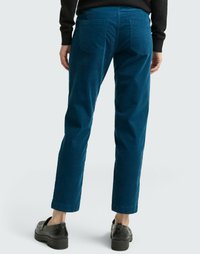 Blue corduroy trousers with a straight leg and back pockets, featuring a textured fabric and a clean hem. Worn with black shoes.