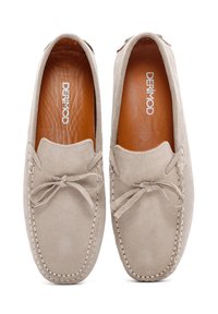 Beige Wildleder-Loafer mit genähten Details und einer Schleifenakzent an der Vorderseite. Lederinnensohle, flache Sohle und abgerundete Zehenform.