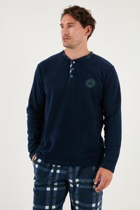Námornícky fleecový sveter s dlhými rukávmi a zapínaním henley, zelenými akcentmi a logom. V kombinácii s kockovanými fleecovými pyžamovými nohavicami.