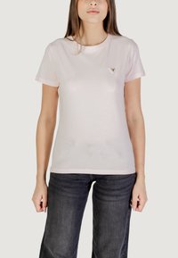 T-shirt rosa chiaro a maniche corte realizzato in tessuto morbido, con un piccolo logo triangolare sul petto. Abbinato a jeans scuri.