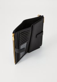 Black leather wallet with gold hardware, featuring multiple card slots and a clear ID window. The design includes a zip closure and a strap.