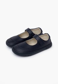Zapatos Mary Jane de cuero negro con una correa de velcro, punta redonda, parte superior texturizada y suela de goma. Interior forrado con tela beige.