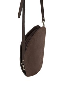 Borsa a tracolla in suede marrone con forma curva, dotata di chiusura con zip, tracolla resistente e texture liscia. Gli accenti includono hardware argentato.