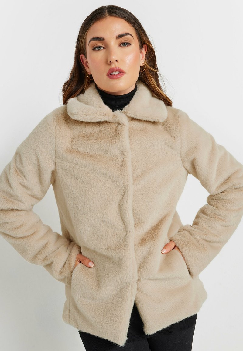 Beige fuskpälsjacka med en mjuk textur, krage, framknappar och sidofickor, designad med en avslappnad silhuett.
