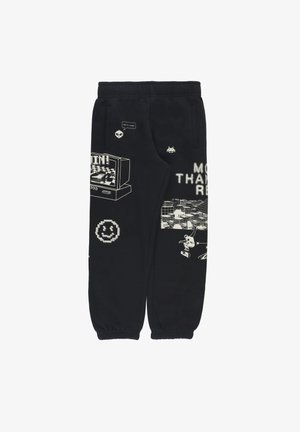 Pantaloni della tuta neri realizzati in materiale morbido, con disegni grafici bianchi, inclusi una TV, una faccina sorridente e dettagli testuali. Vita elastica.