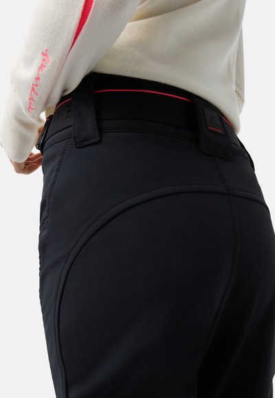 Schwarze Sporthose mit glatter Textur, versehen mit einer kontrastierenden Naht und einem schwarzen Bund mit roten Akzenten.
