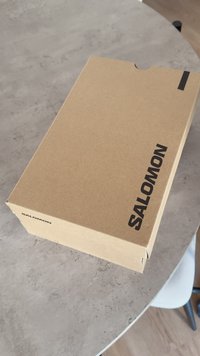 Kartoninė batų dėžutė su matinio rudo paviršiaus apdaila. Dėžutėje yra juodas „SALOMON“ logotipas šone, su išpjova lengvam atidarymui.