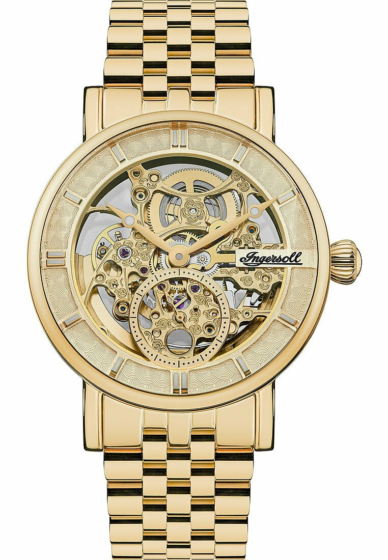 Montre squelette dorée avec un cadran transparent révélant des engrenages complexes. Bracelet à maillons et lunette texturée avec des index horaires.