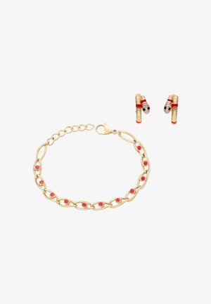 Kultainen ketjurannenkoru, jossa punaisia helmiraitoja, ja pari kultaisia käärmeaiheisia korvakoruja, joissa on punaisia ja mustia yksityiskohtia, valkoisella taustalla.