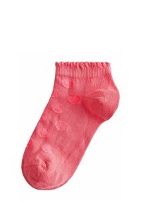 Rosa bomullsocka som når anklarna med ribbad kant, med rundade prickmönster och en slät textur, designad för komfort och passform.