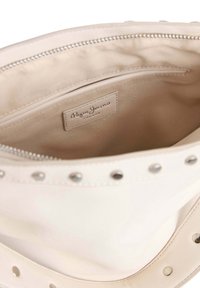 White leather bag interior featuring a zip closure and a beige lining. Includes a label with "Pepe Jeans London" and silver studs along the edge.
