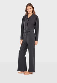 Dunkelgraues Zweiteiler-Loungewear-Set mit einer kurzärmeligen, knopfbaren Bluse und weiten Hosen, aus weichem Stoff gefertigt.