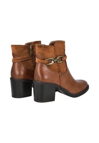 Botas de tobillo marrones con una combinación de cuero liso y ante. Presentan un tacón cuadrado, cremallera lateral y una correa decorativa con hebilla.