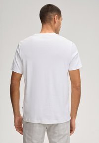Witte T-shirt met korte mouwen en een ronde hals, gemaakt van zachte katoenen stof. Heeft een losse pasvorm en een eenvoudig ontwerp zonder zichtbare afbeeldingen.