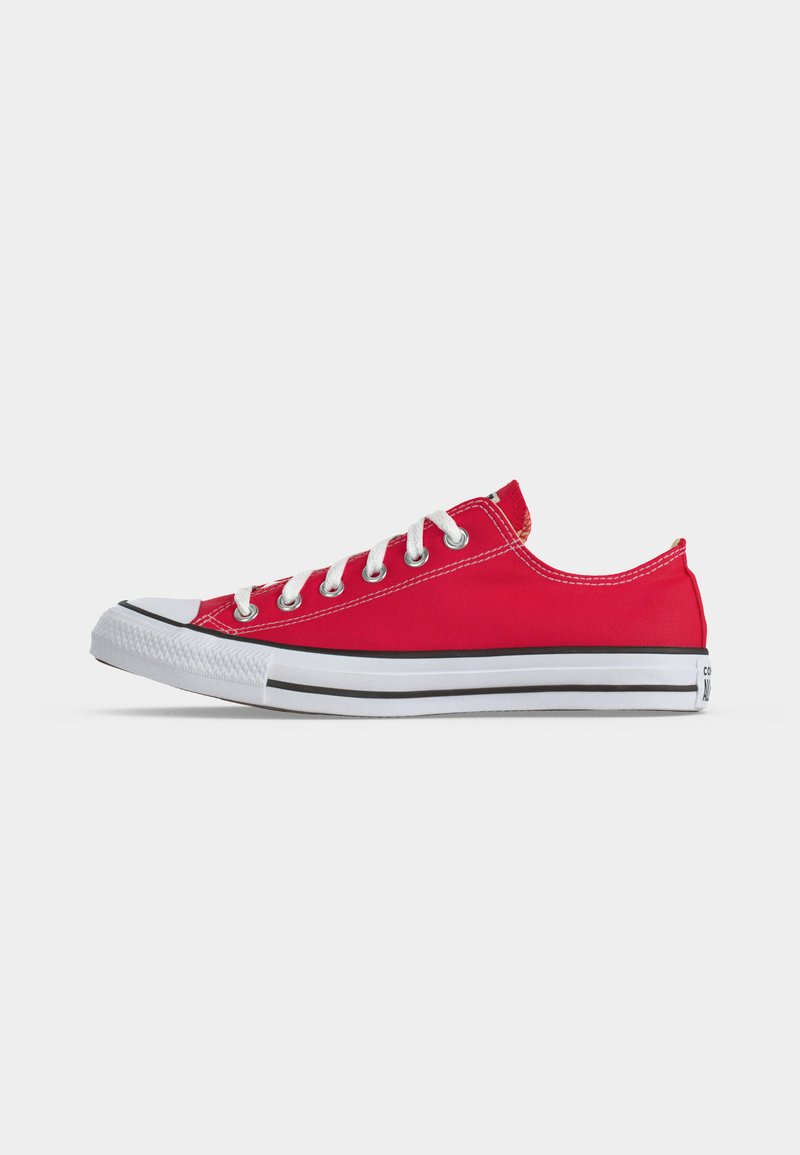 Sneaker bassa rossa in tela con lacci bianchi e suola in gomma, vista da lato su sfondo chiaro uniforme.