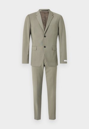 Costume vert olive composé d'un blazer avec des revers crantés et une poche simple, associé à un pantalon slim. Texture de tissu lisse.