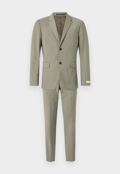 Olivgrüner Anzug, bestehend aus einem Blazer mit Reverskragen und einer einzelnen Tasche, kombiniert mit schmal geschnittenen Hosen. Glatte Stofftextur.