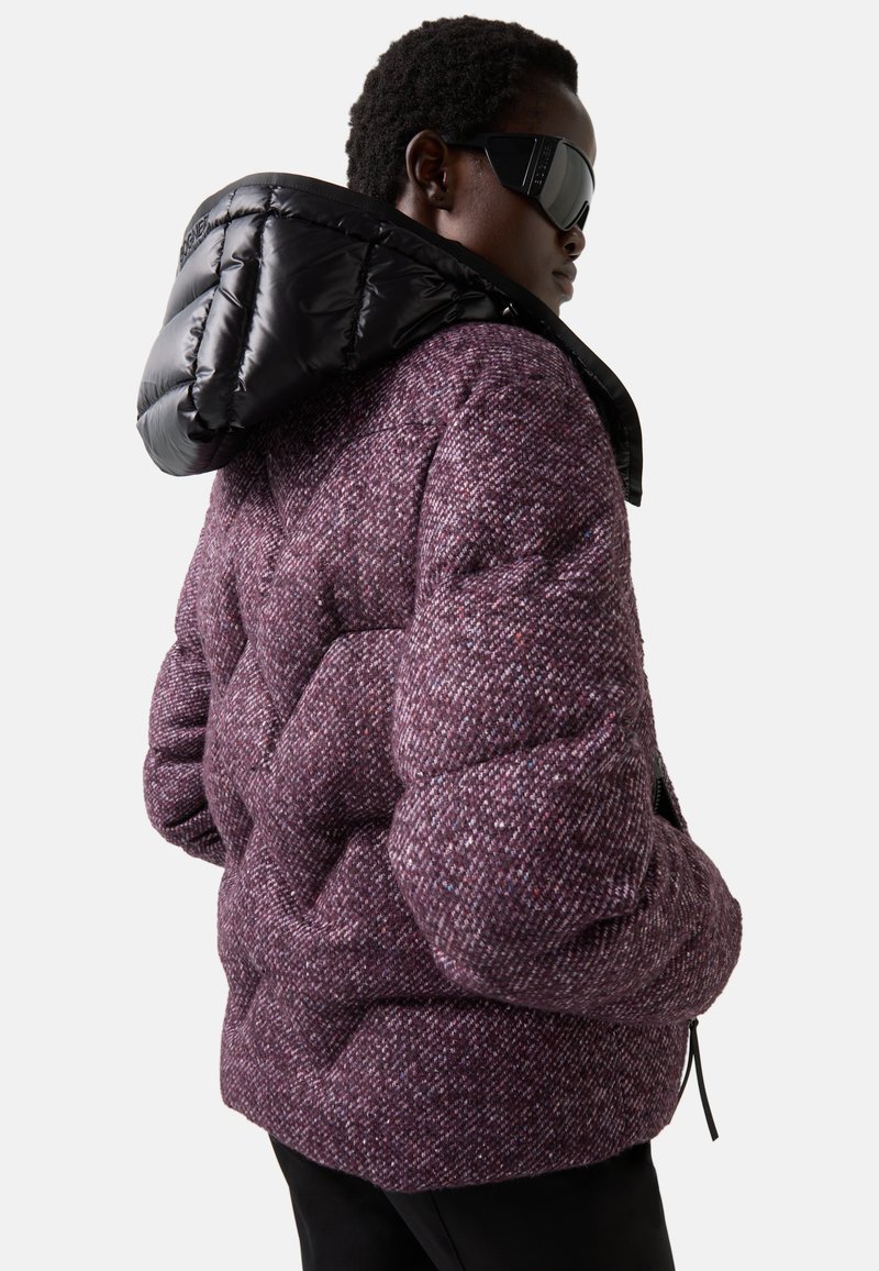 Paarse gestructureerde pufferjack met een afneembare zwarte glanzende capuchon, voorzien van een geometrisch patroon en elastische manchetten en zoom.