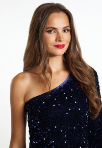 Rochie bleumarin, cu un singur umăr, cu textură strălucitoare și accente lucioase. Prezintă un design ajustat și un decolteu din satin neted.